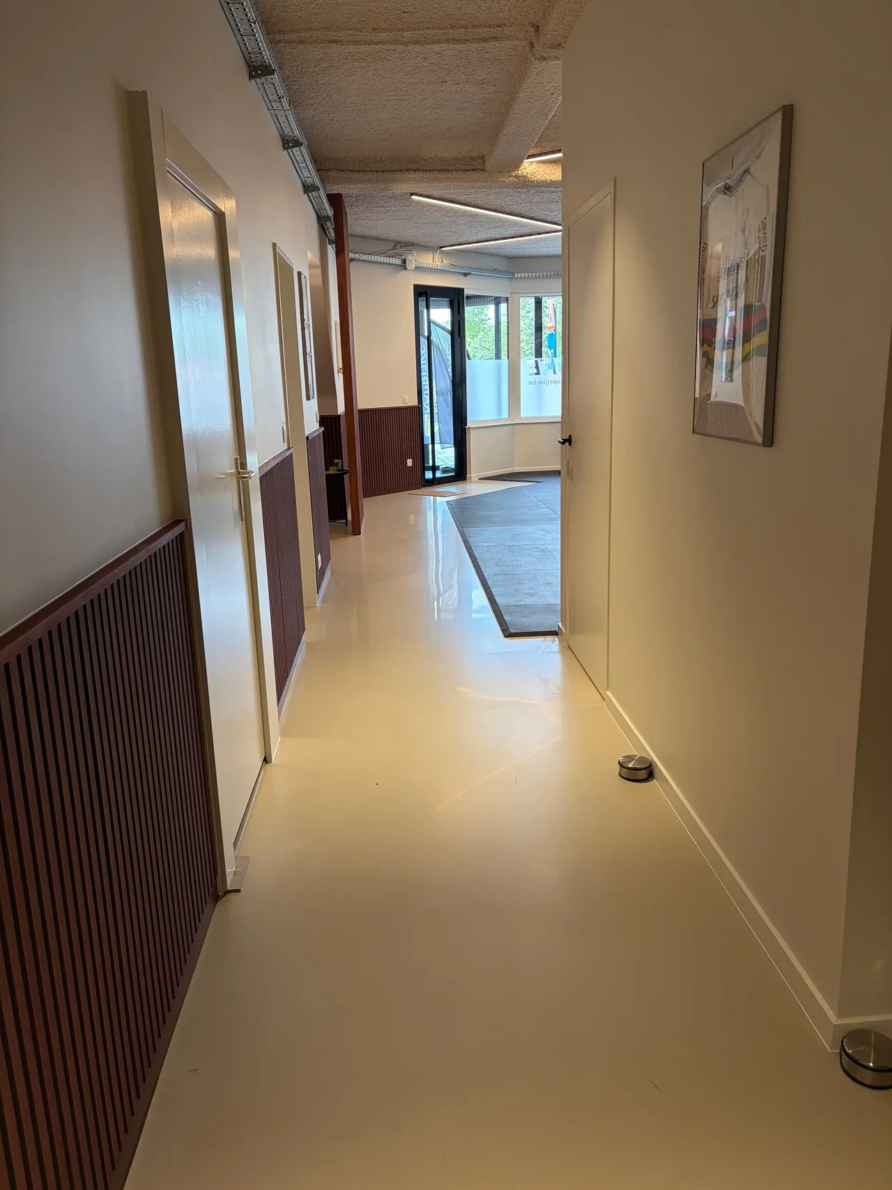 Gang met behandelkamers en de ingang achteraan