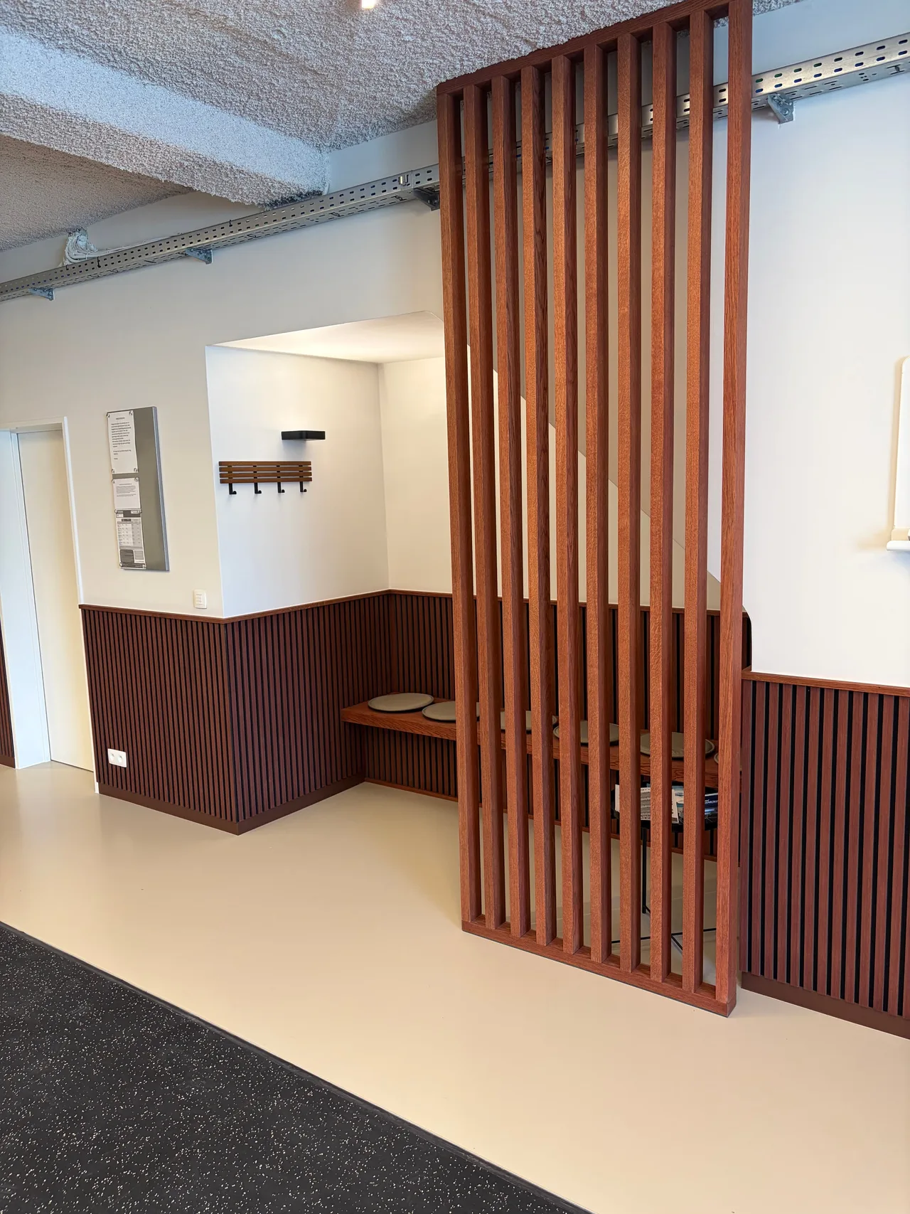Onthaal met een houten lattenwand en een zitbank